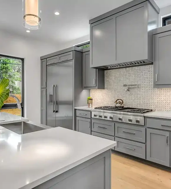 Modern grey kitchen with stainless steel appliances and white countertops